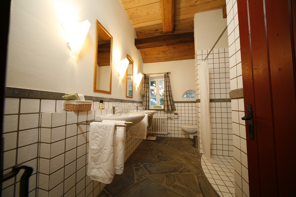 FeWo Harms Hoff – Bad Badezimmer mit zwei Waschbecken, Toilette, barrierefreier Dusche und Fenstern